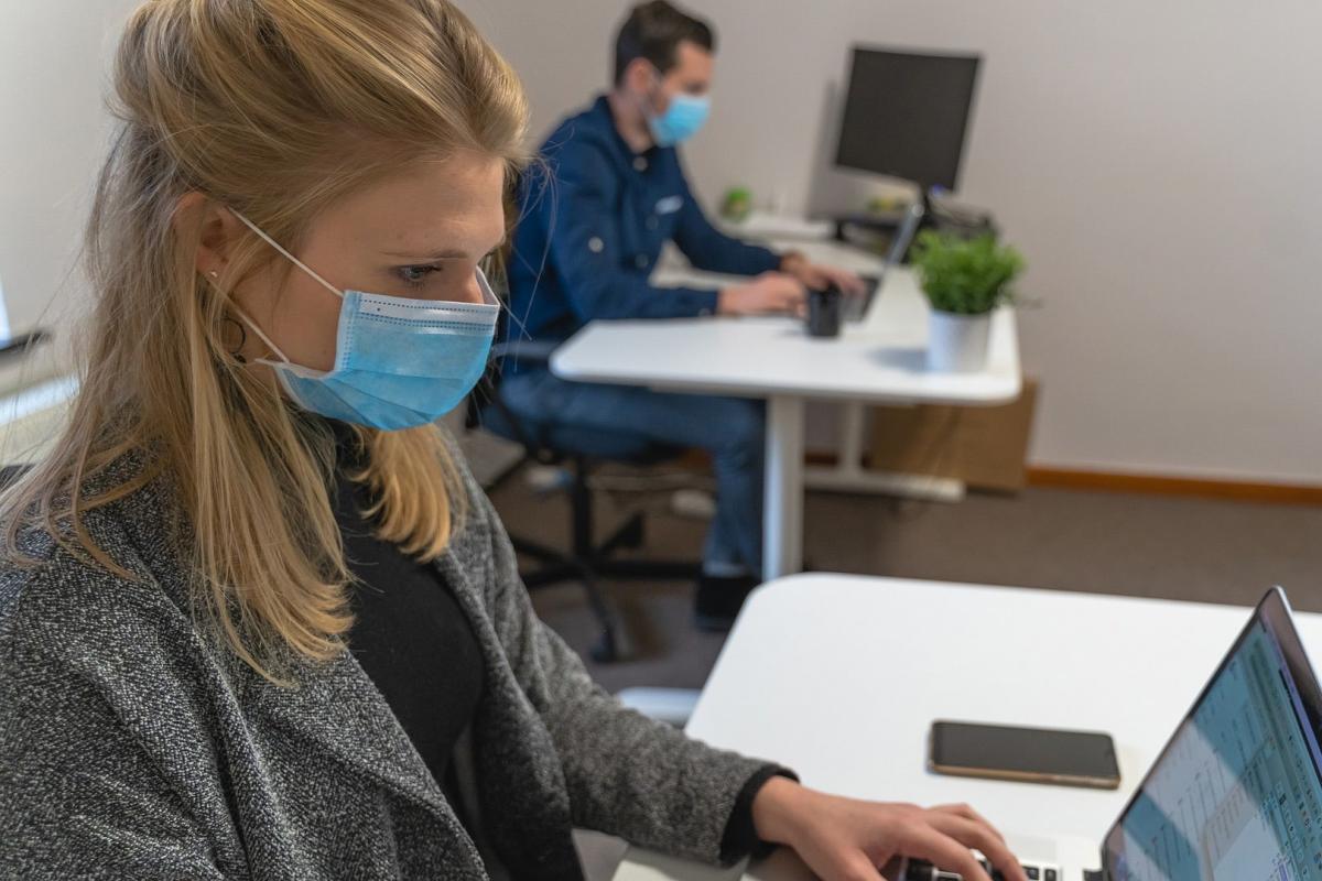 Employees working at desks with medical masks on